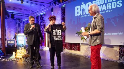 padeluund und Rena Tangens überreichen Rolf Gössner zum Abschied Blumen und ein BigBrotherAwards-T-Shirt.