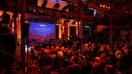 Das Publikum der BigBrotherAwards von hinten fotografiert. Blickrichtung Bühne.