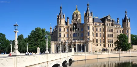 Das Schweriner Schloss mit einer Brücke als Zufahrt. Der Himmel ist strahlend blau.
