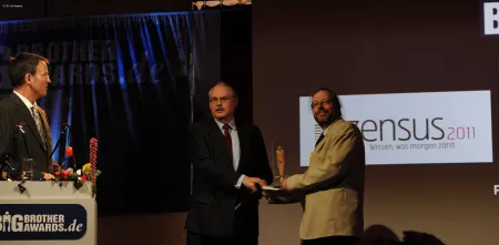 Werner Hülsmann übergibt auf der Bühne den BigBrotherAward an Herrn Prof. Dr. Gert G. Wagner.