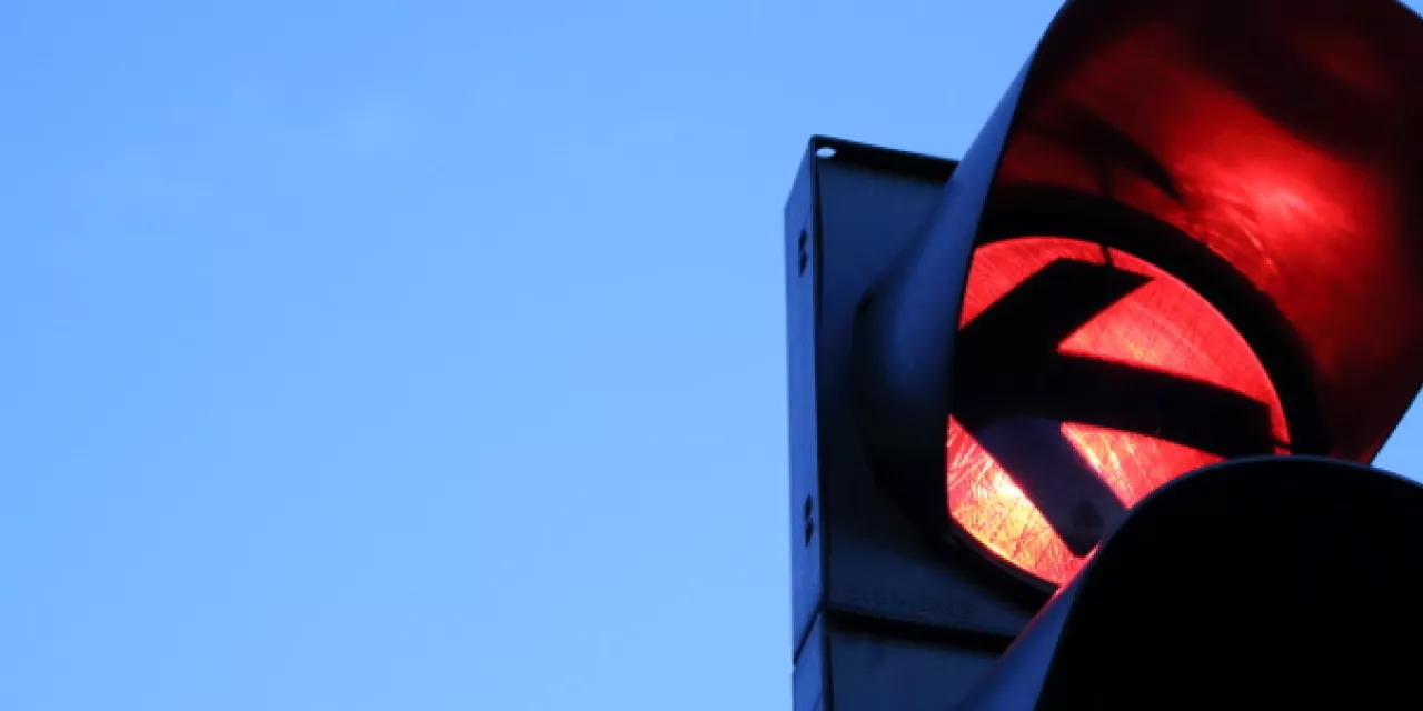 Detailaufnahme einer roten Ampel mit Pfeil nach links.